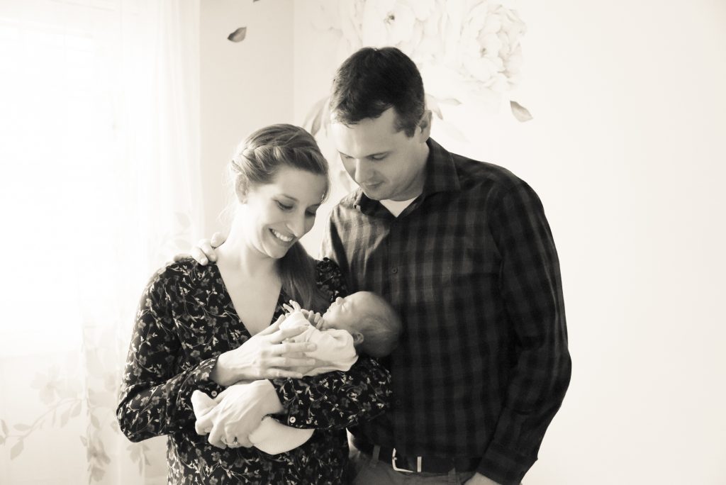 mom and dad holding a newborn baby in black and white