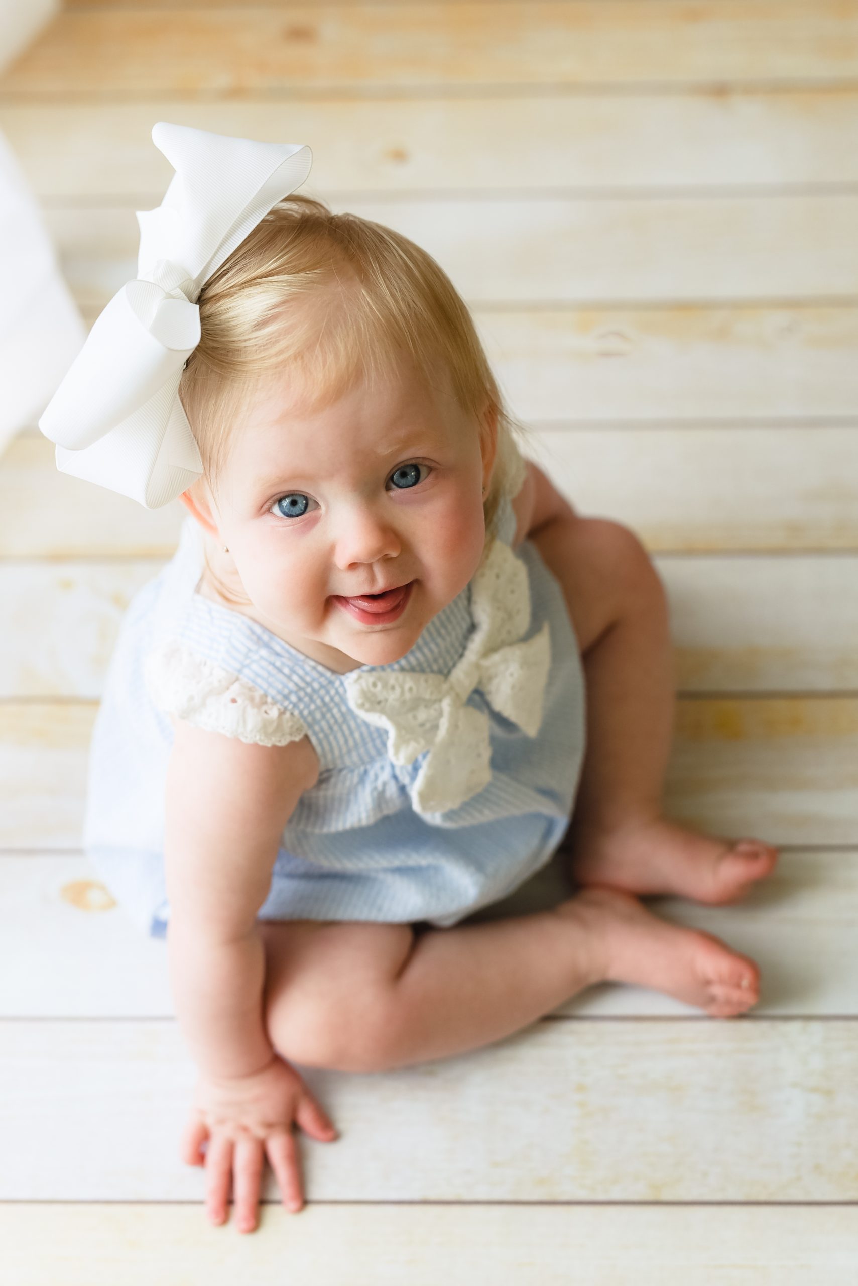 Baby girl with white bow milestone session